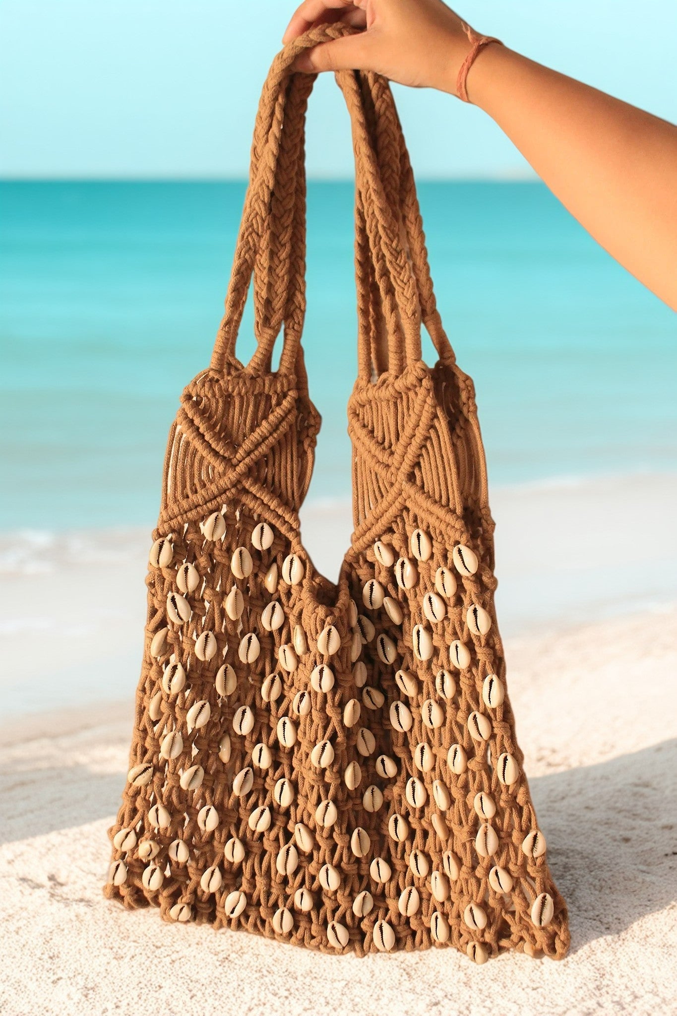 A girl holding a beige color bag with corn shells for everyday use on a beach, or for casual outing