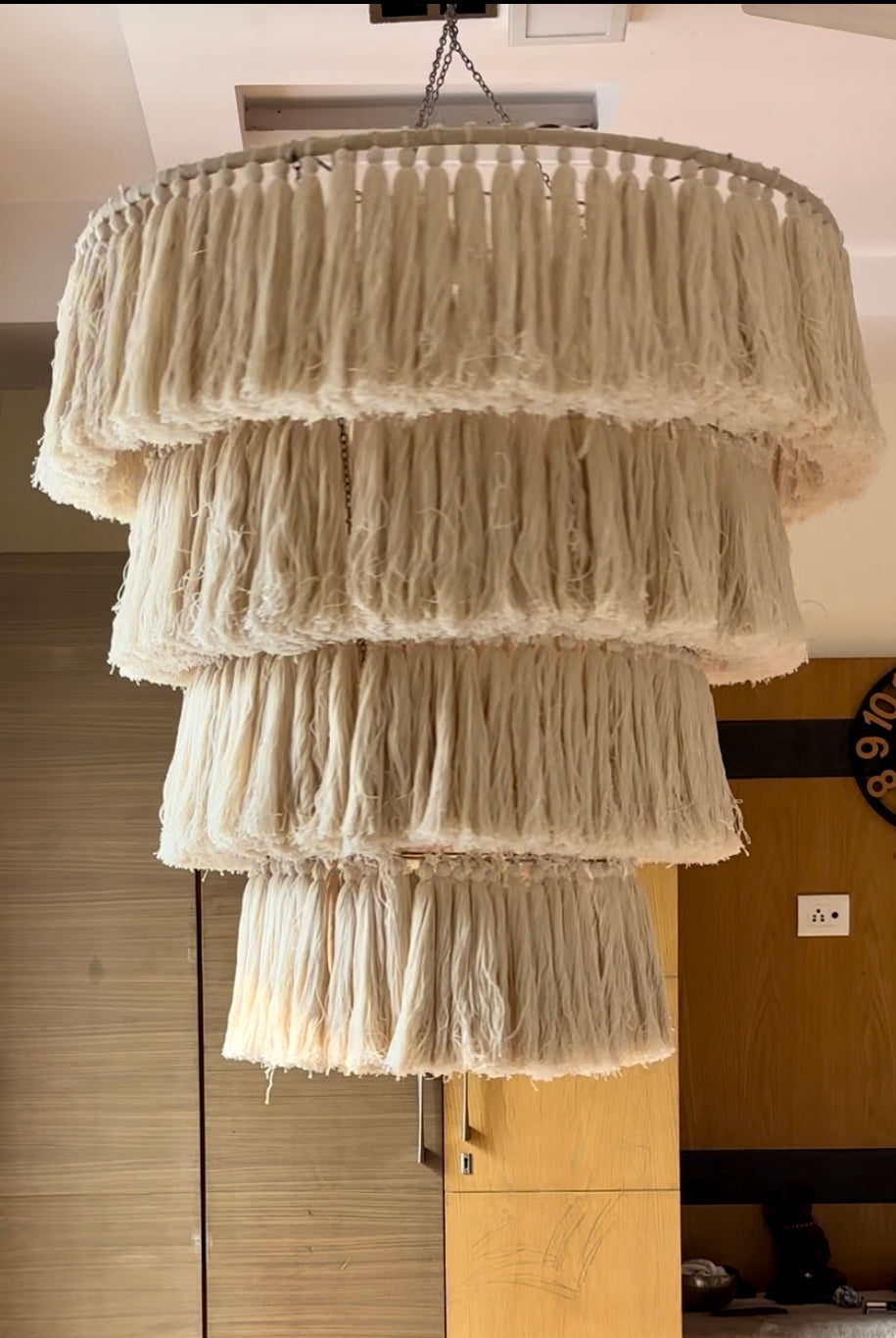 Oversized macrame chandelier with tiered fringe design styled in a modern room