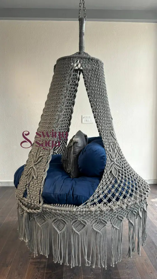 side view of grey color hanging hammock swing with comfortable mattress and 2 macrame  cushions.