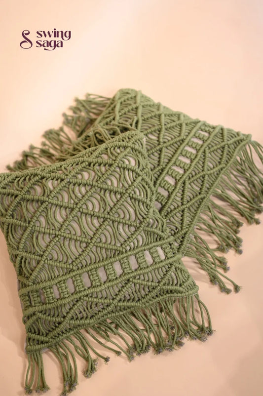 Green macrame throw blanket with fringes on a beige background