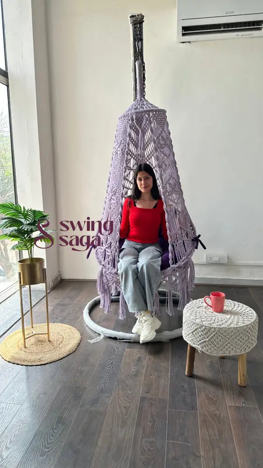 front view of a girl on a macrame swing with stand in an aesthetic setup.