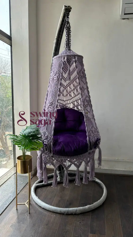 Front view of purple swing with stand in an aesthetic setup. swing hanged on a stand in round shape