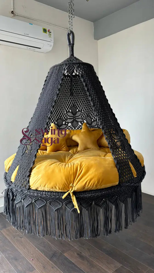 Front image of macrame grey bed swing with yellow mattress and 2 star cushions in seude material. soft and fluffy