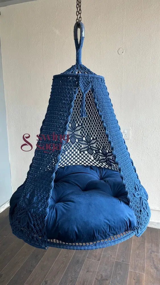 A blue macrame hammock swing for two people built round in shape. flower patterns at the back. handcrafted