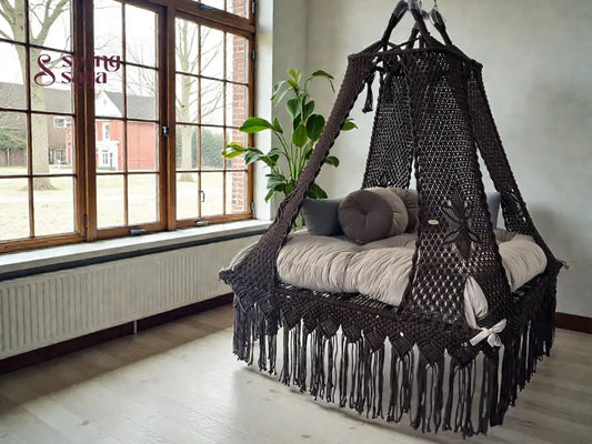 Coke colored square bed swing in an indoor setting, with plush round cushions.