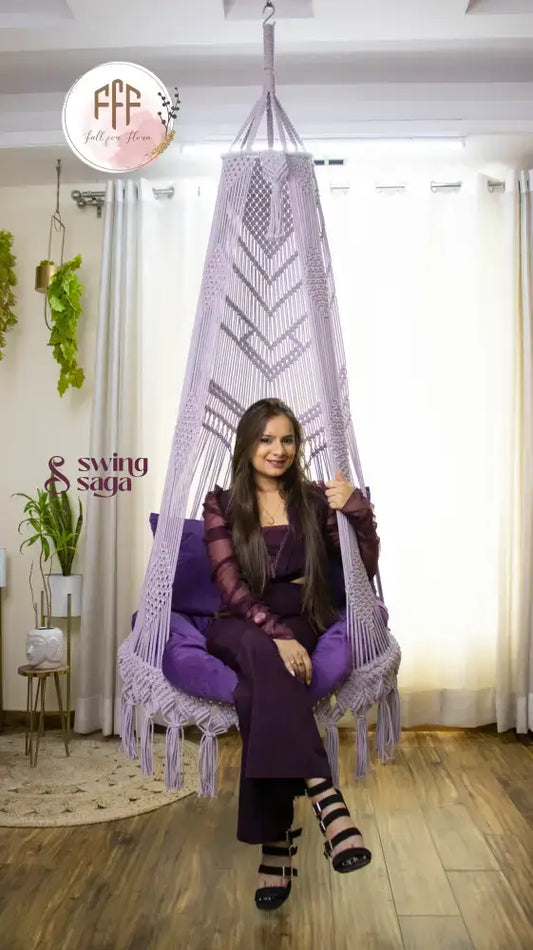 A girl is sitting on a purple chair hammock hanging swing.
