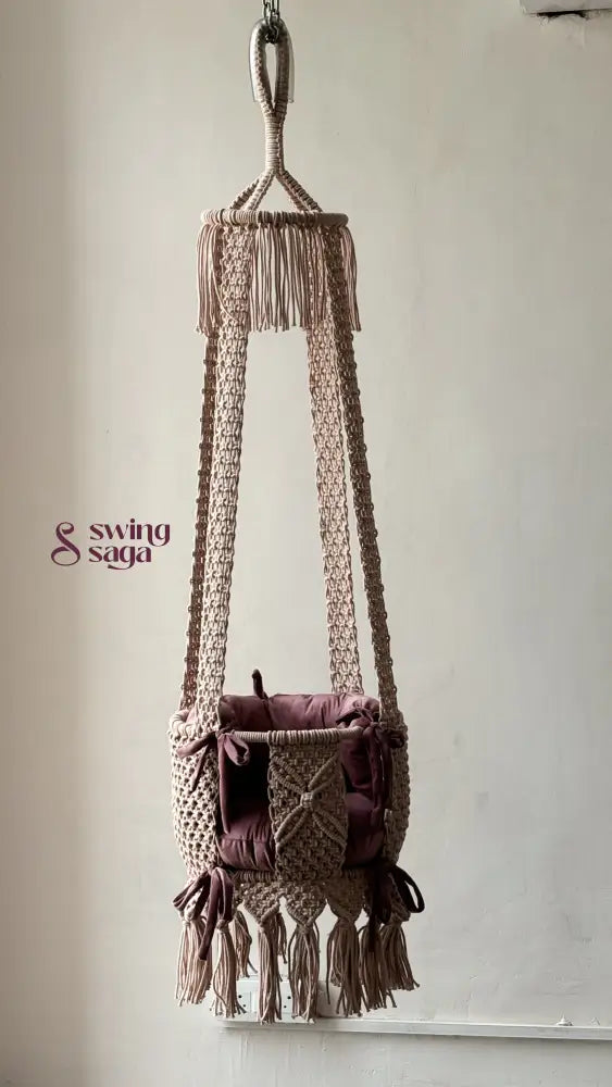 Full image of baby pink macrame handcrafted swing in a room setting.