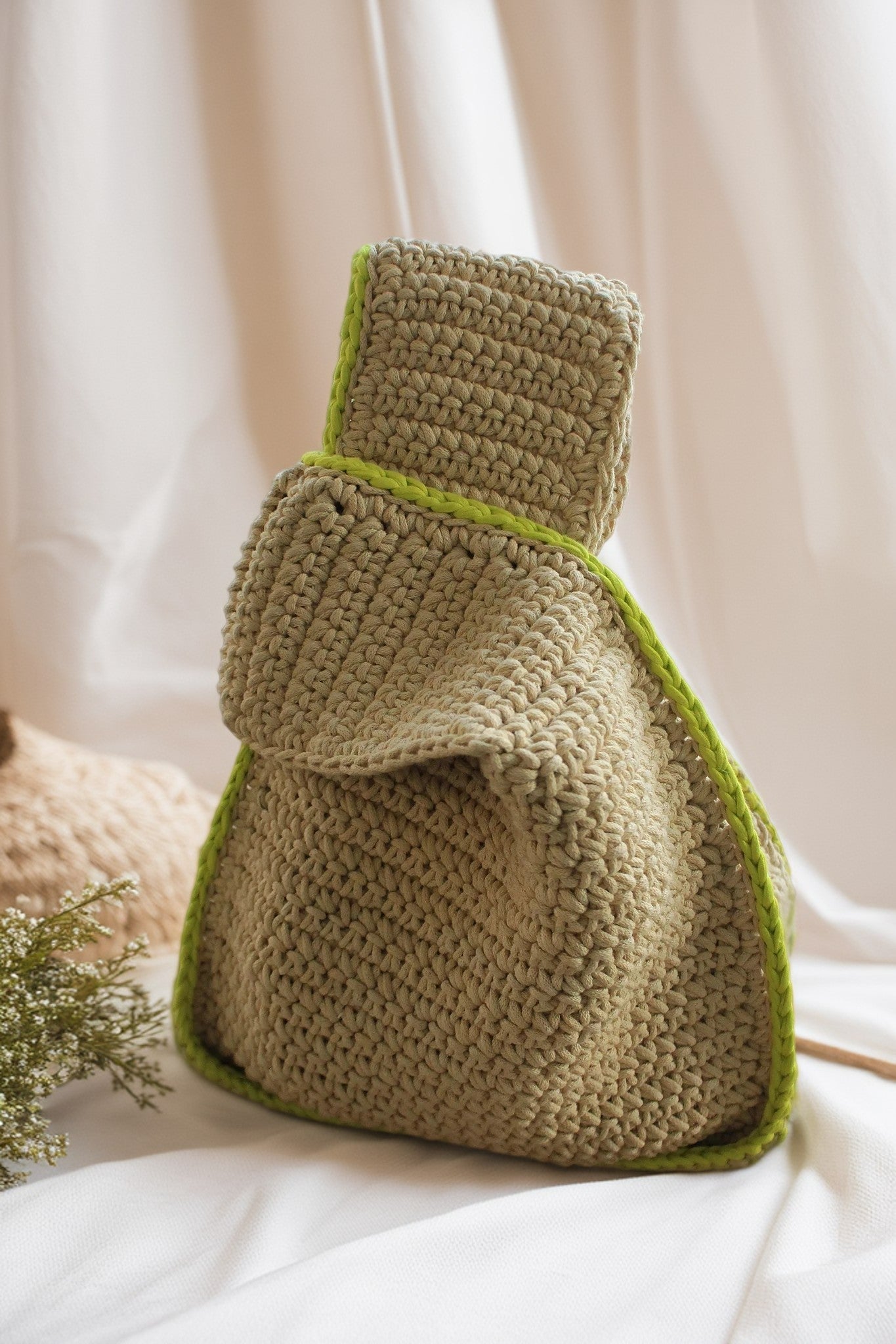 handcrafted beige crochet handbag with green lining on the corner for everyday use.
