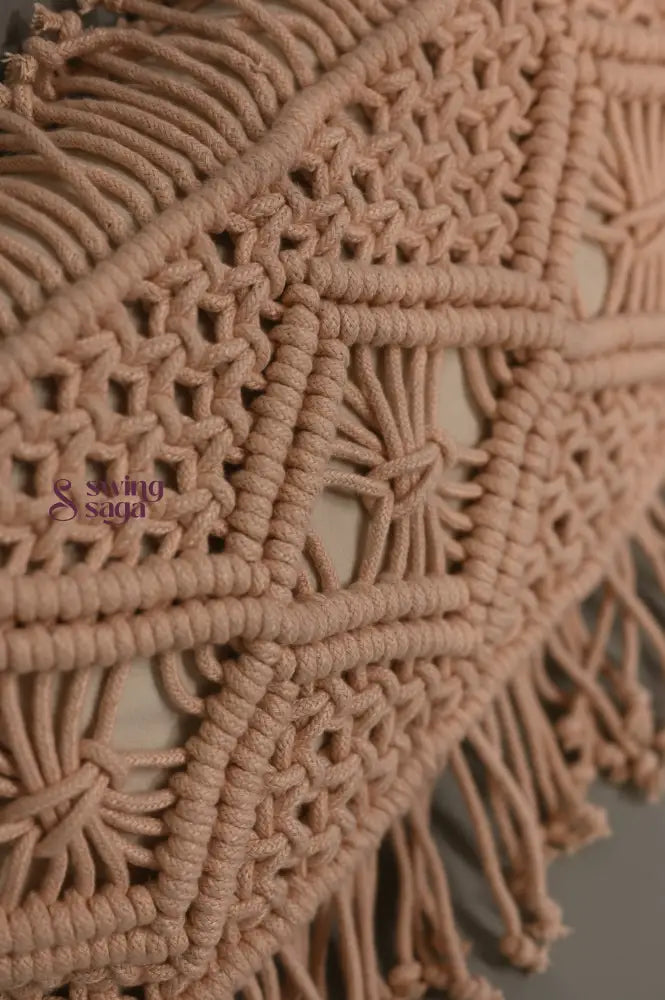 Close-up of a beige macrame wall hanging with intricate patterns and fringes.
