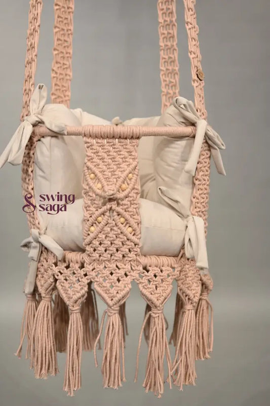 Macrame baby swing with tassels on a plain background