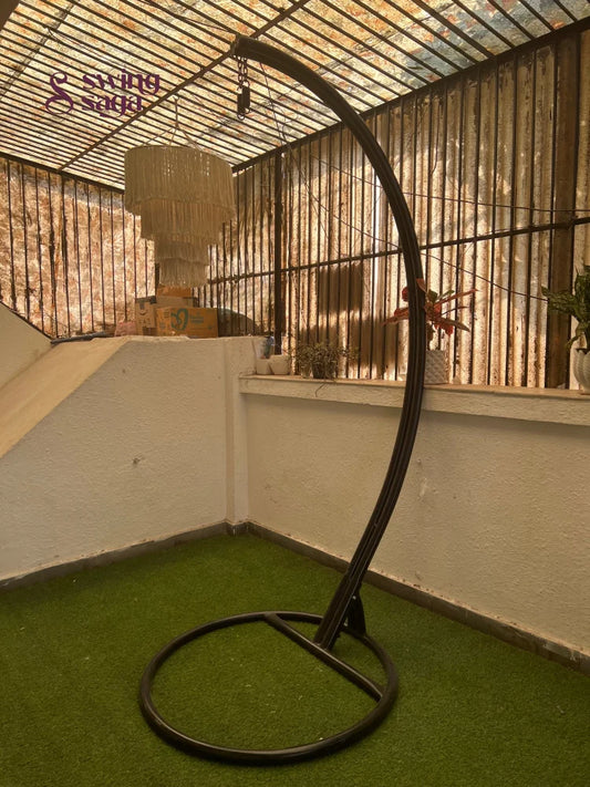 black metal stand with curved arm on a faux grass mat.