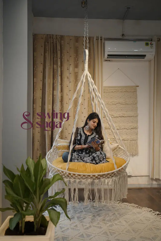 Woman sitting in a woven chair in a room with a plant and air conditioner.