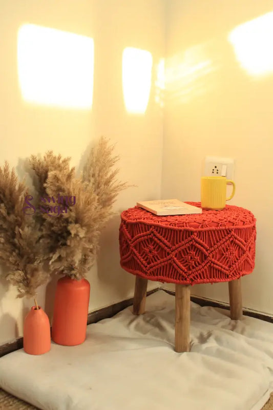 Orange Macrame Ottoman with yellow coffee mug and terracotta vase.