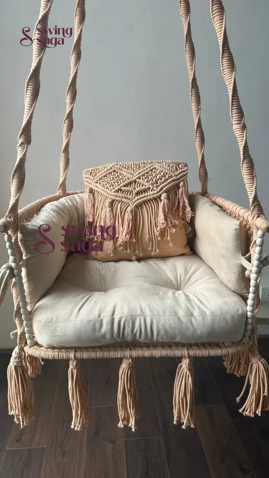 Hanging chair hammock swing with white mattress and peach cushion.