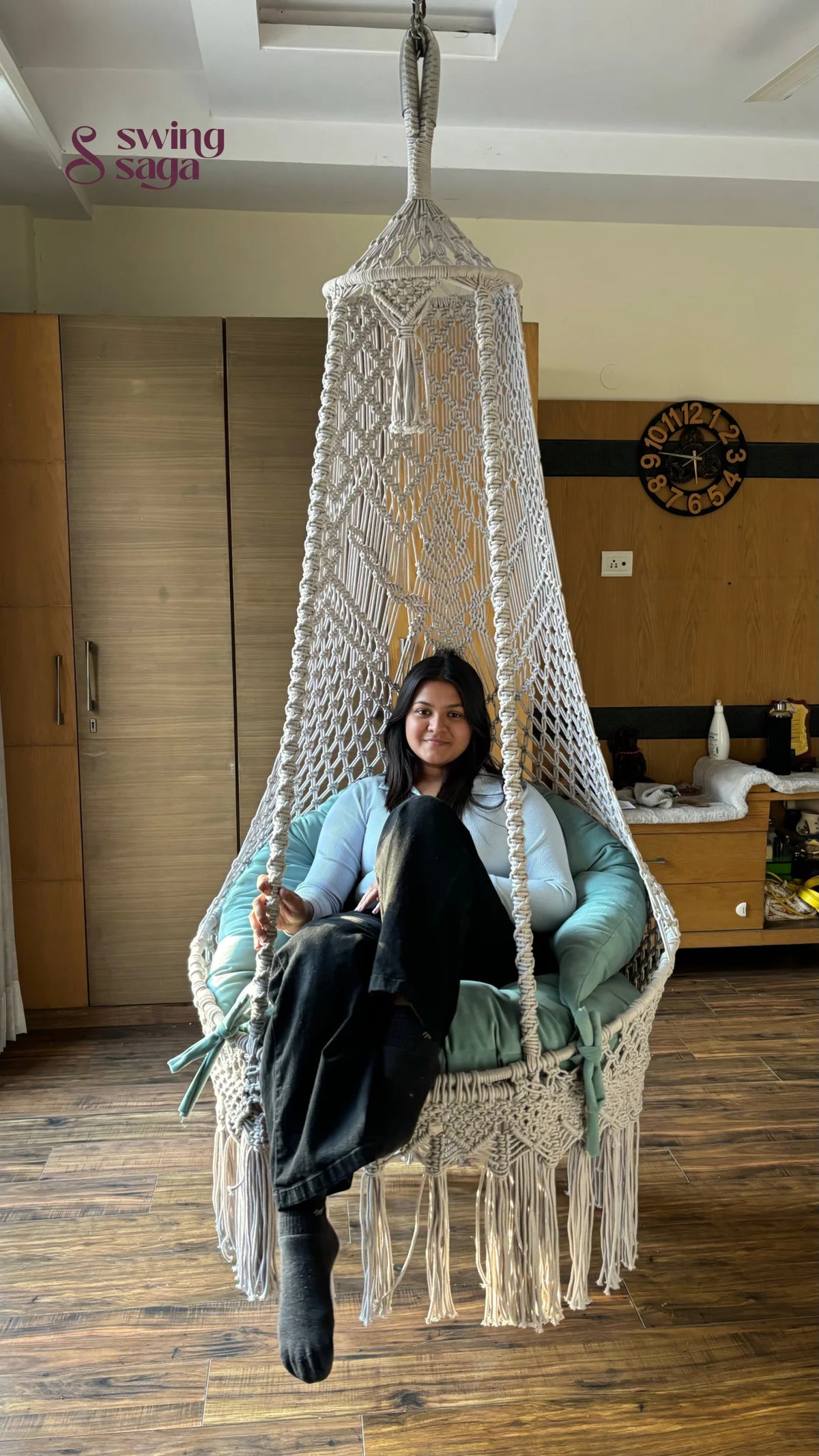 A girl sitting on a white hanging chair swing.