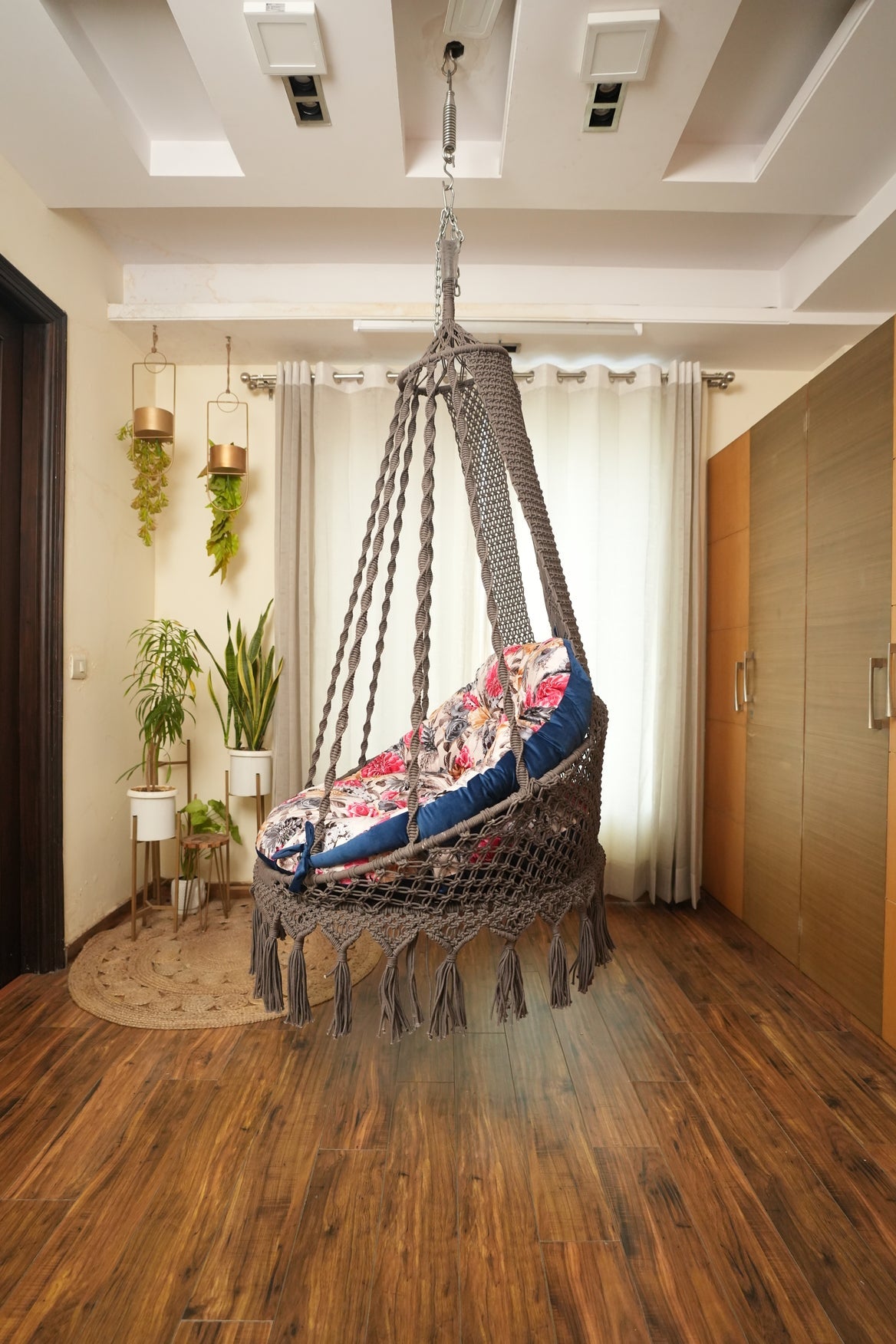 brown chair swing hanging in a wooden flooring room.