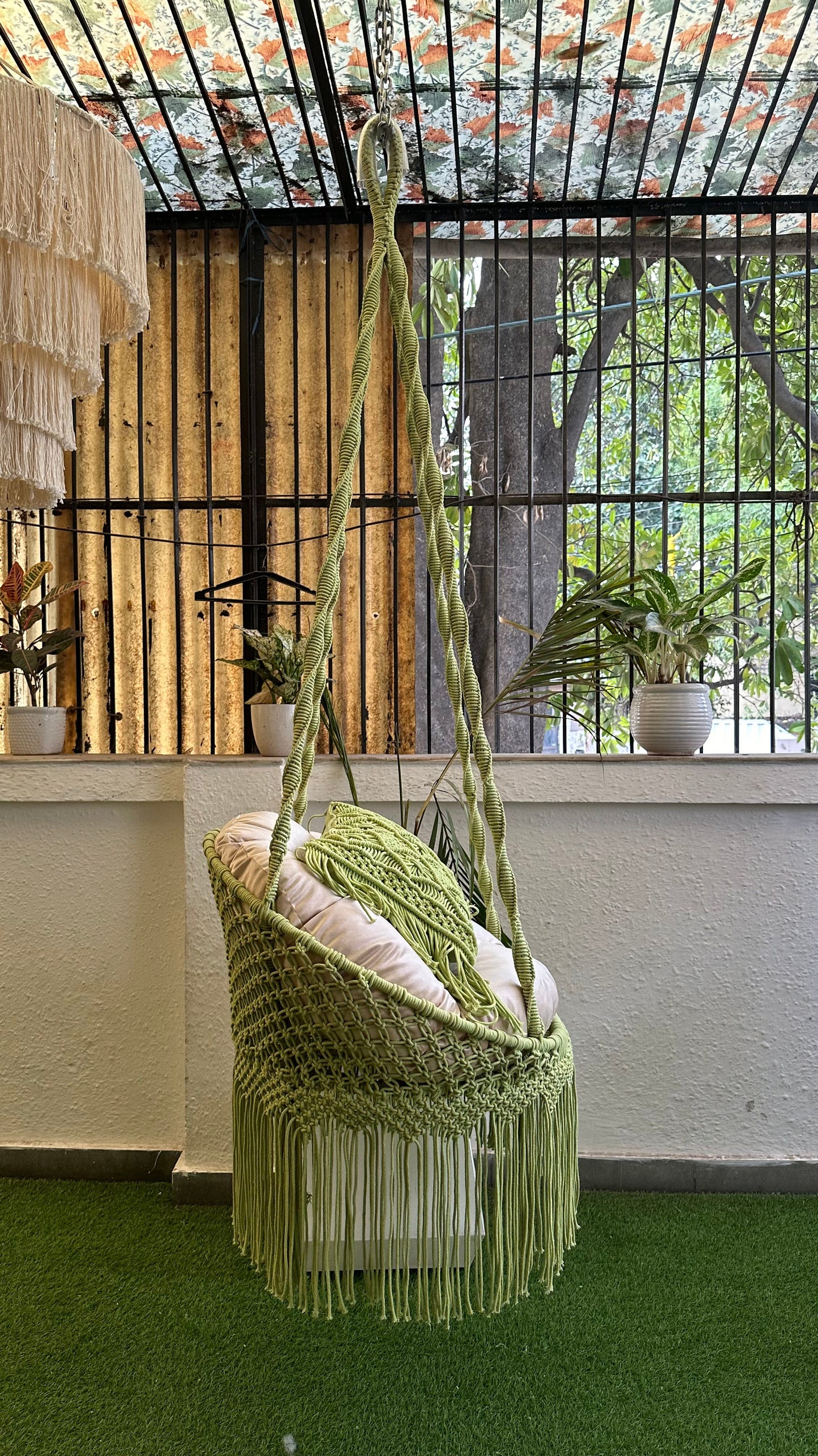 Handcrafted macrame chair hammock hanging swing in green color.