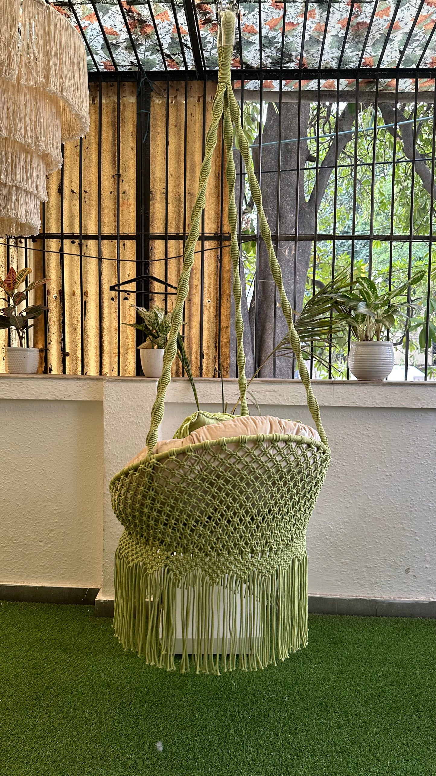 Handcrafted macrame chair  hanging swing in green color.