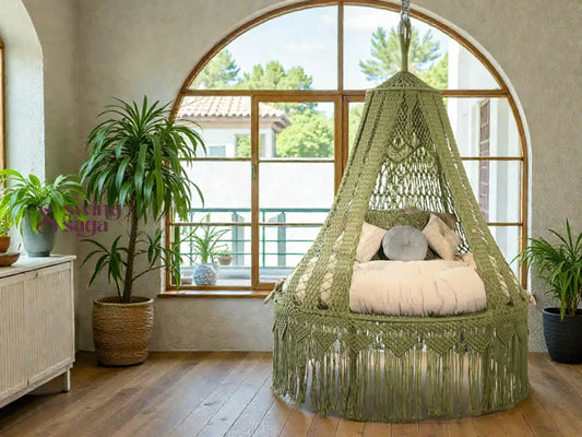 Green macrame hanging chair in a room with large windows and a plant.