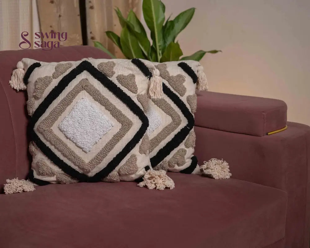 pair of square sofa cushions in white color with black tufted print.