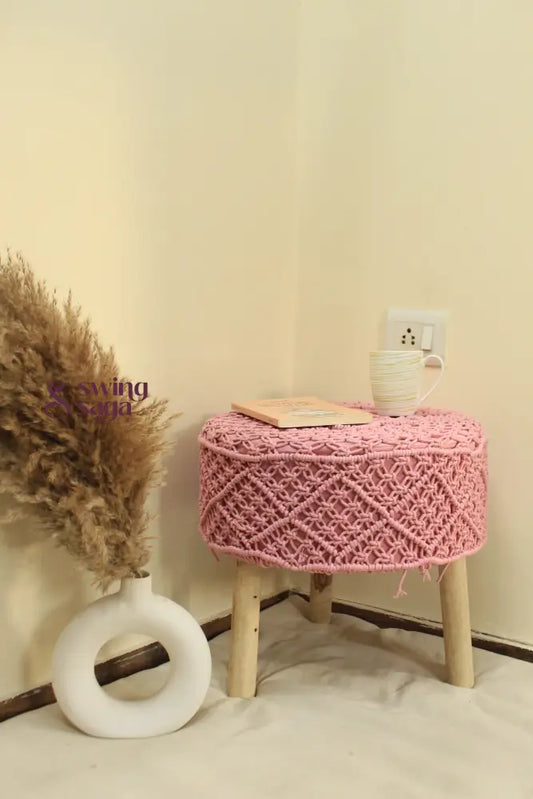 Pink macrame ottoman with a pampas grass holder.