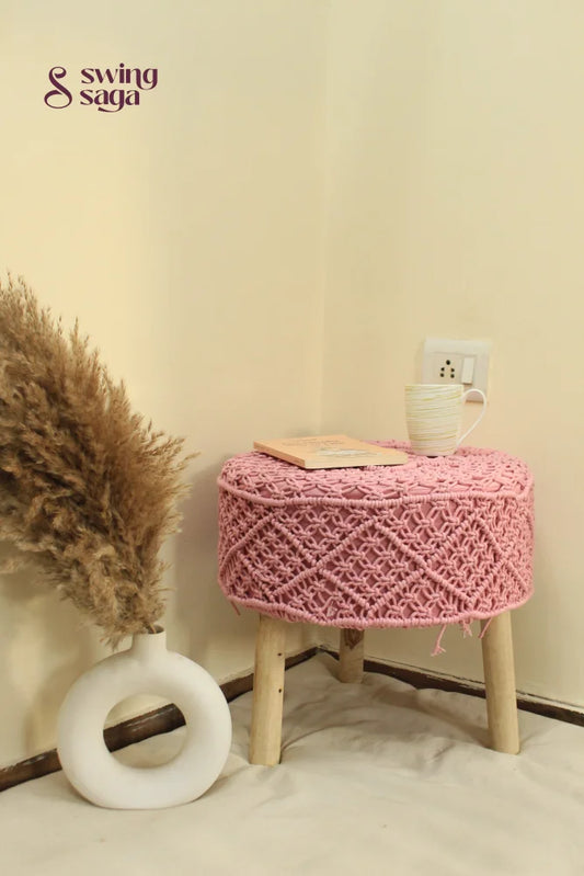 Pink macrame ottoman with a pampas grass holder.