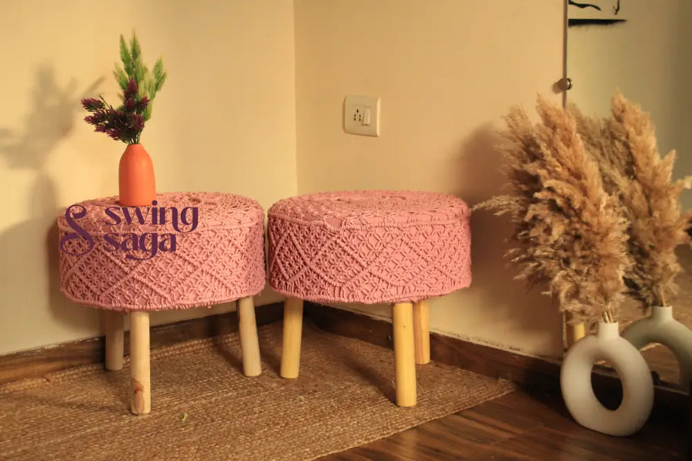 Two pink woven stools with wooden legs in a room setting.