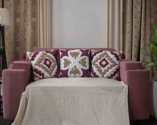 Cream and maroon patterned cushion with decorative fabric design.