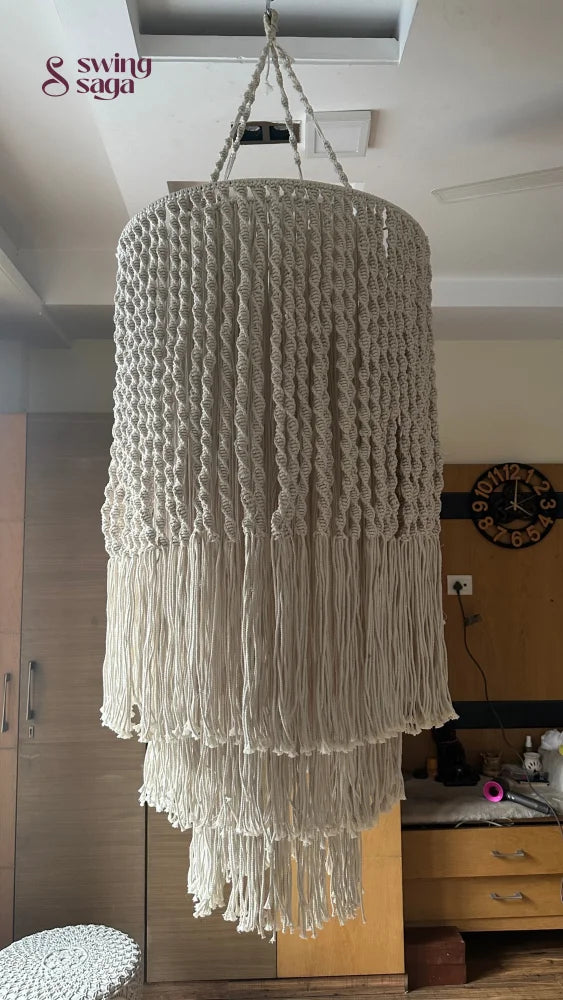 Handcrafted macrame chandelier with tiered fringe detailing displayed in a contemporary indoor setting.