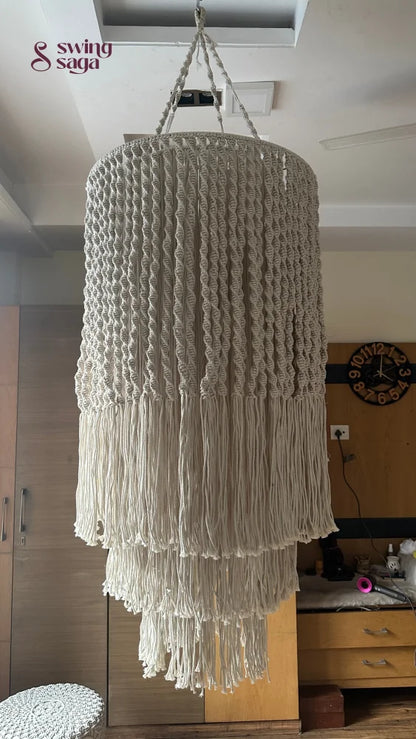 Handcrafted macrame chandelier with tiered fringe detailing displayed in a contemporary indoor setting.