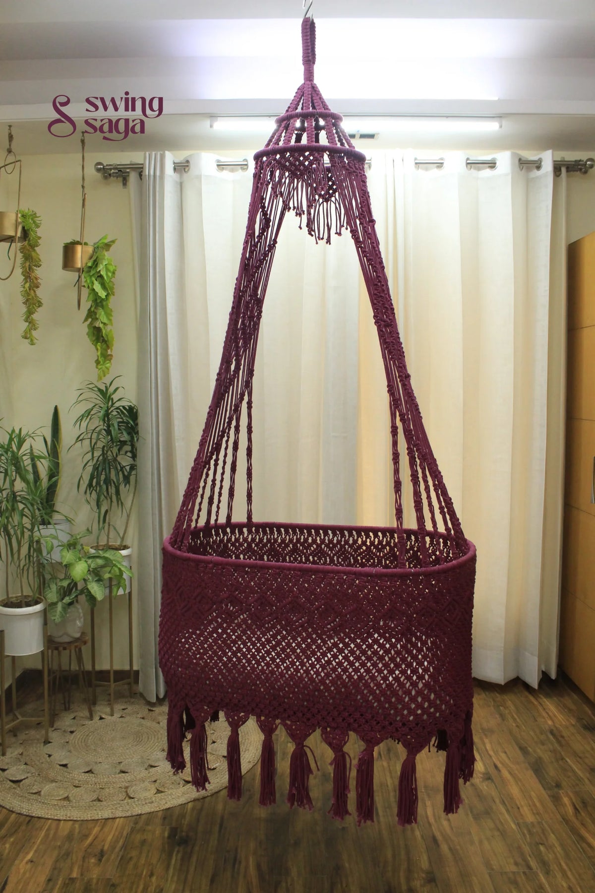 Brick Colored macrame baby bassinet hanging in an indoor setting.