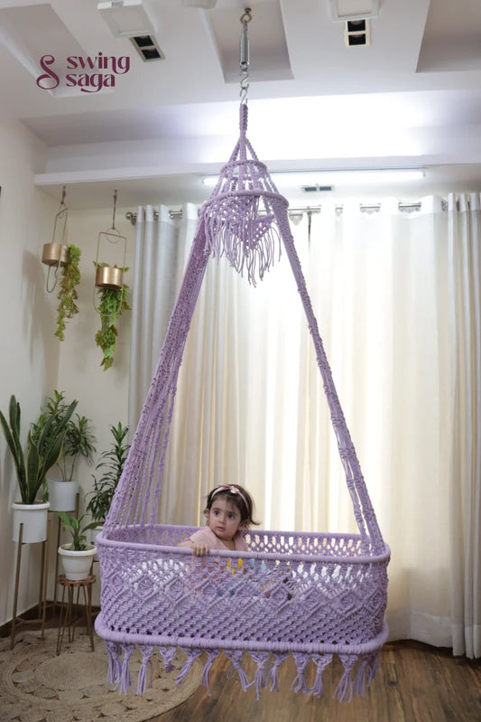 Baby sitting in a lavender macrame hanging cradle swing by Swing Saga in a modern indoor home setting