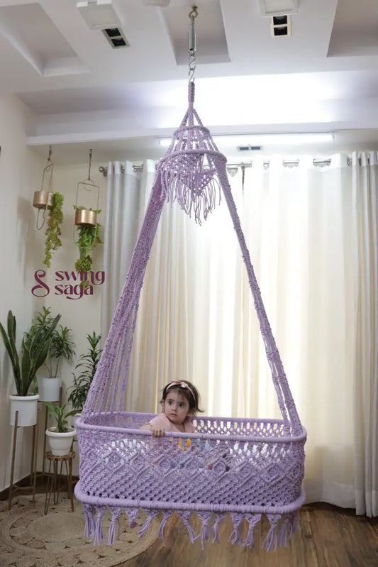 Baby sitting in a lavender macrame hanging cradle swing by Swing Saga in a modern indoor home setting
