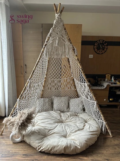 white handmade macrame teepee with white mattress and 3 small square cushions.