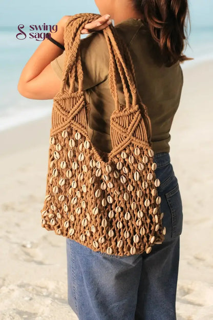 macrame beach bag on a girl shoulder in a brown color for everyday use.