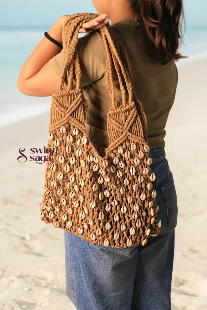 macrame beach bag on a girl shoulder in a brown color for everyday use.