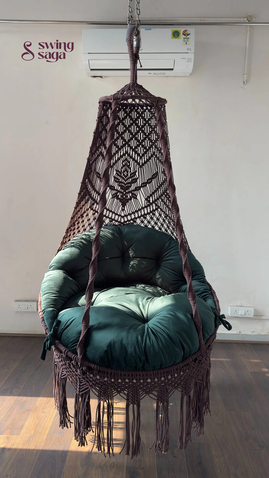 Hanging macrame chair with green cushion in a room with an air conditioner.