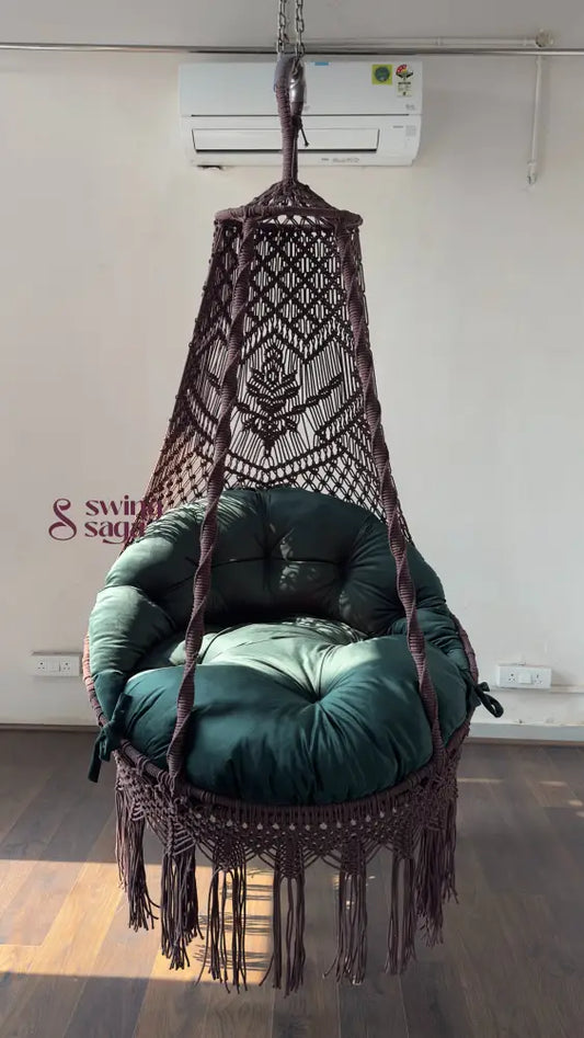 Hanging macrame chair with green cushion in a room with an air conditioner.