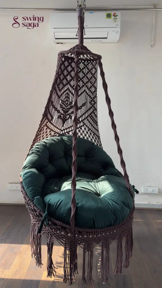 Hanging chair swing with green cushion and mattress.