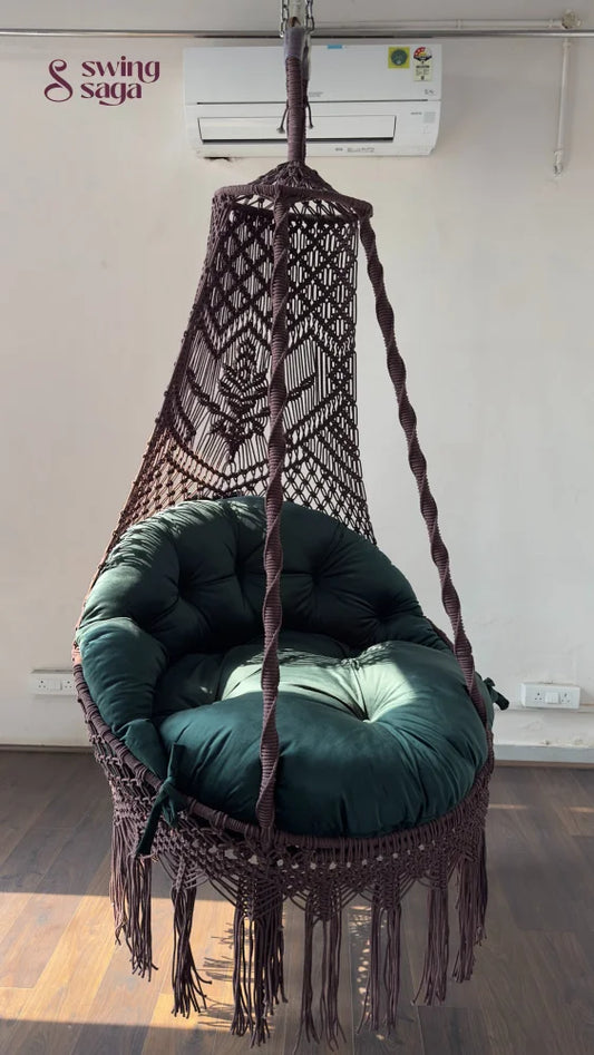 Hanging chair swing with green cushion and mattress.