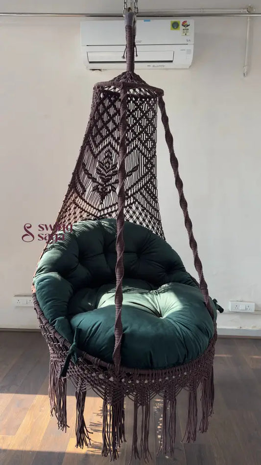 Hanging chair swing with green cushion and mattress.