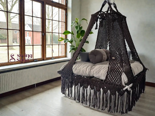Coke colored square bed swing in an indoor setting, with plush round cushions. 