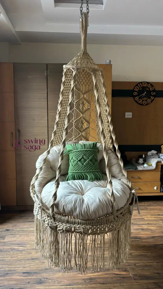 Hanging macrame chair with cushions in a cozy room setting