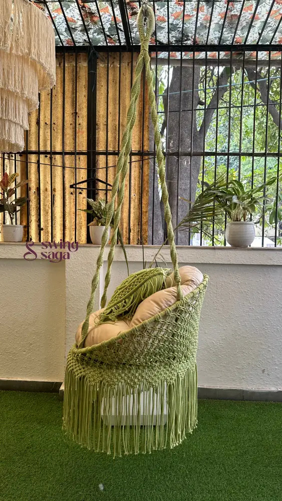 Handcrafted macrame chair hammock hanging swing in green color.
