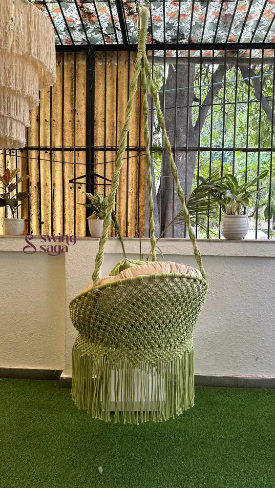 Handcrafted macrame chair hammock hanging swing in green color.