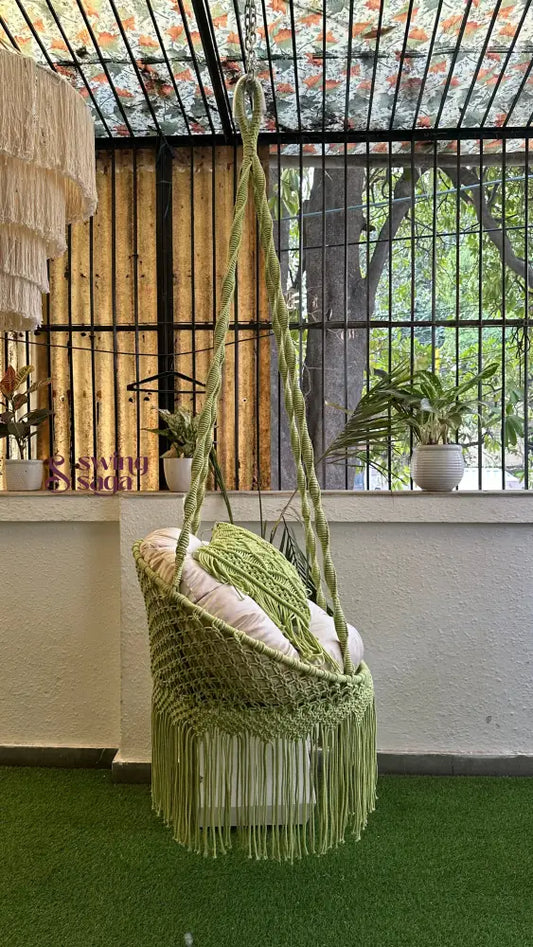 Handcrafted macrame chair hammock hanging swing in green color.