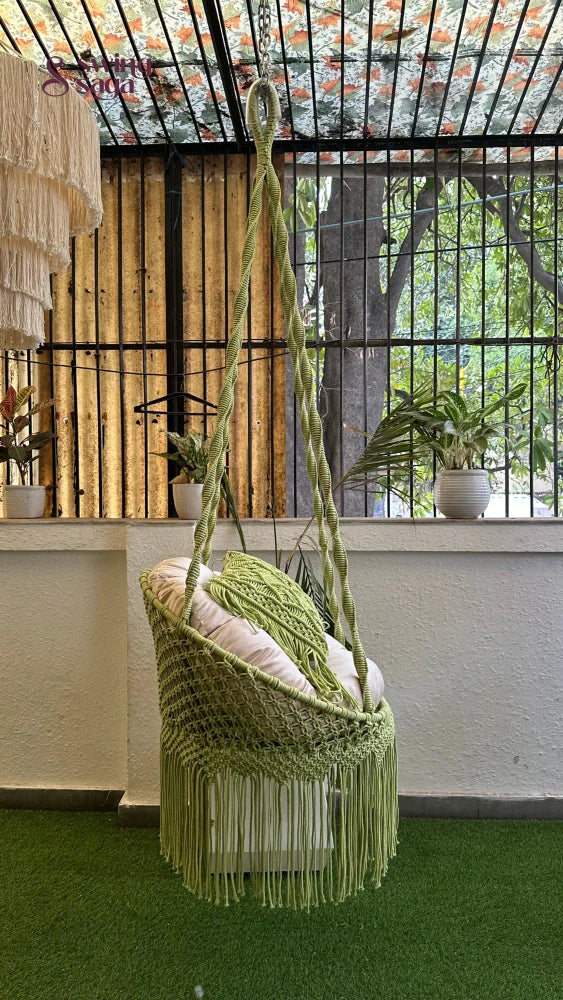 Handcrafted macrame chair hammock hanging swing in green color.