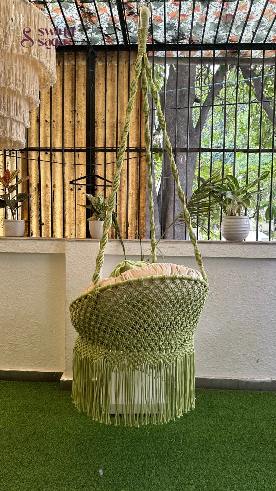 Handcrafted macrame chair hammock hanging swing in green color.