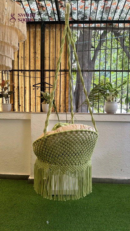 Handcrafted macrame chair hammock hanging swing in green color.