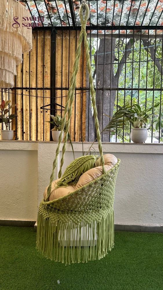 Handcrafted macrame chair hammock hanging swing in green color.
